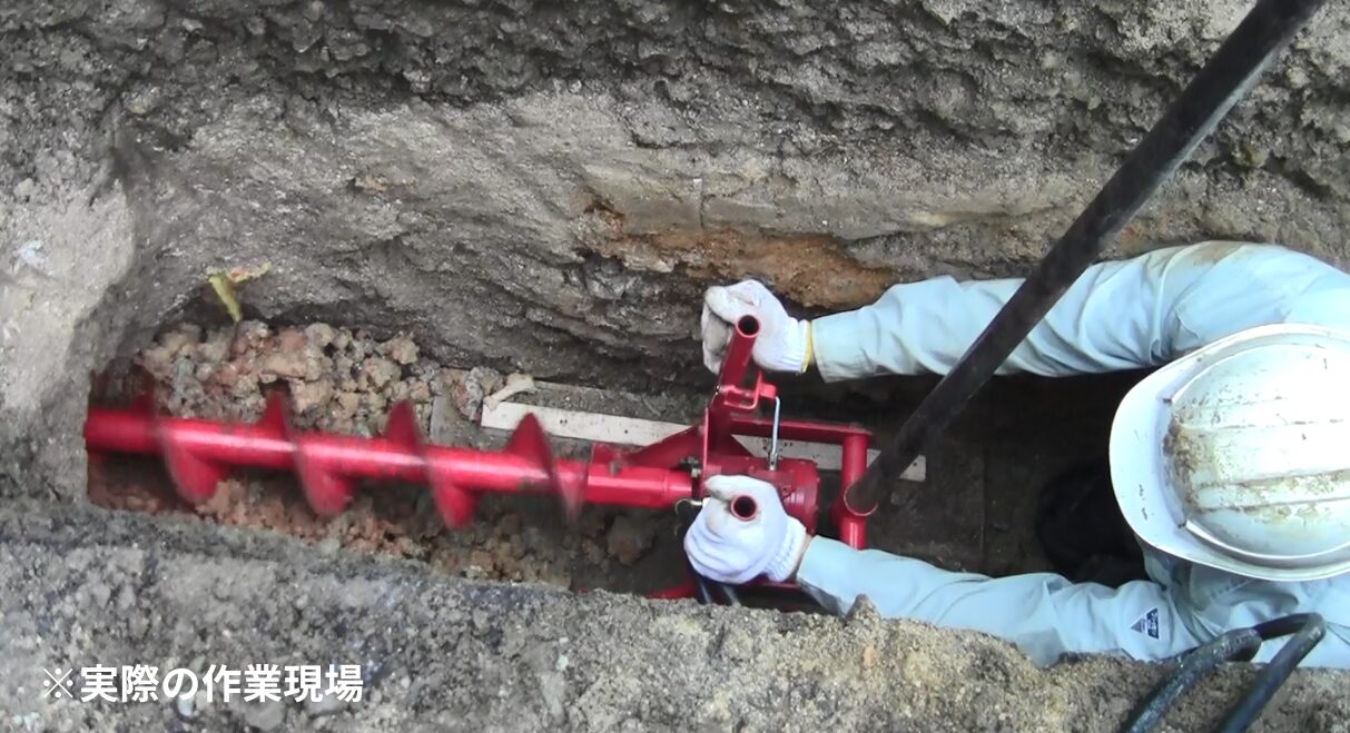 ガス・水道管引き込み現場でハンドオーガーを使った横掘り作業写真